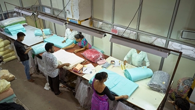 Workers folding and wrapping textiles in plastic. (iStock photo)