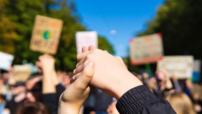 Two young people at a rally holding hands. (Shutterstock)