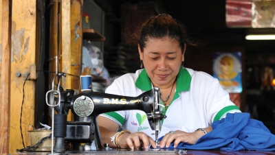 A woman operates a sewing machine in a garments factory. (Shutterstock)