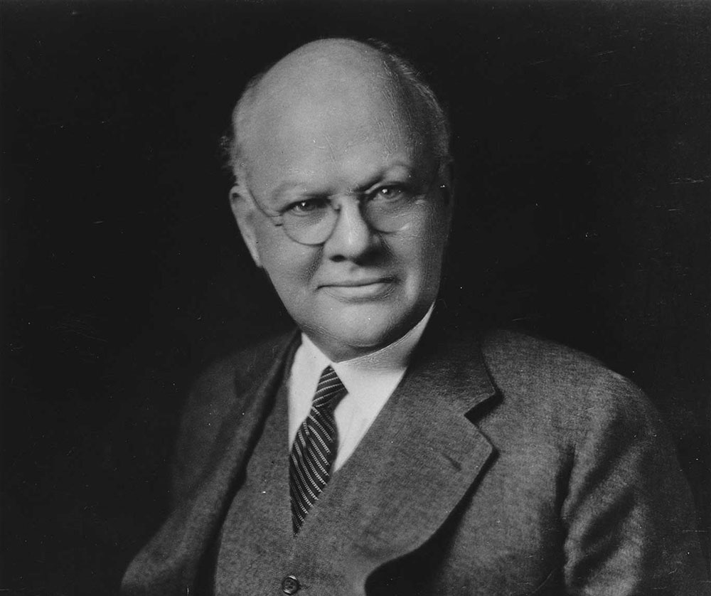 Black and white portrait of HBS Dean Wallace B. Donham standing in suit.