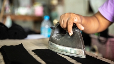 Using a hand iron in a garment factory. (Shutterstock)